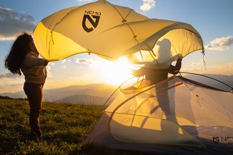 Two people building a tent by Nemo during the sunet