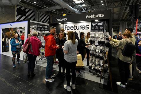 Visitors browse products and talk with exhibitors at the Feetures booth during IRX.